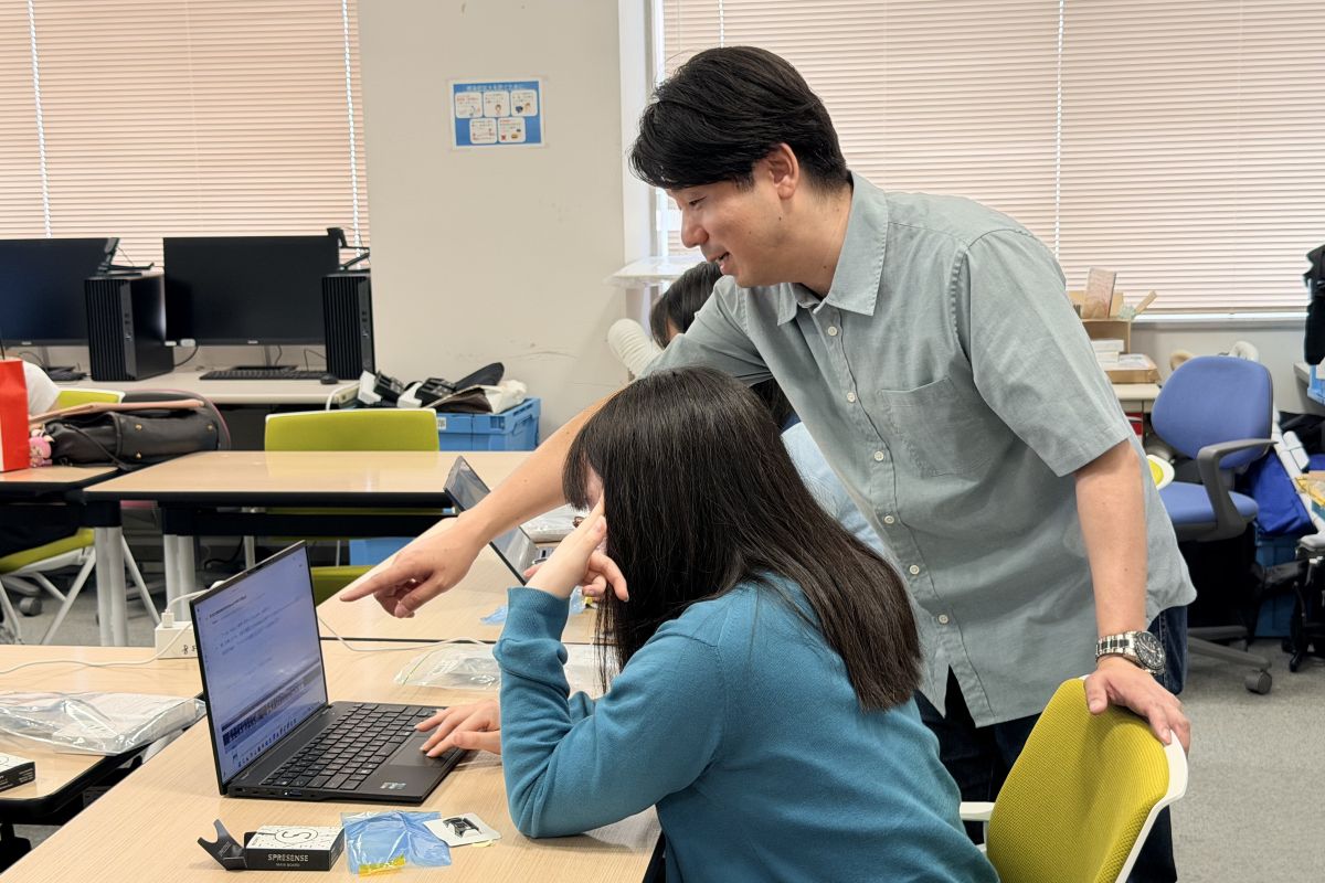 学生からの質問に対し，教員がコードについてアドバイスする様子